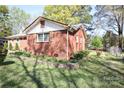 A cozy brick home featuring a well-maintained yard, side garden, and a classic design with mature trees at 3220 Wiseman Dr, Charlotte, NC 28227