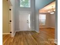 Inviting foyer featuring hardwood floors, a high ceiling, and a view into the dining room at 3712 Autumn Gold Ct, Charlotte, NC 28278