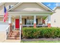Inviting covered front porch with a cozy porch swing and steps leading up to a bright red front door at 4058 Canvas Ave, Rock Hill, SC 29732