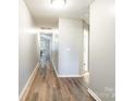 Well-lit hallway with wood-look flooring offering easy access to various rooms in the home at 4058 Canvas Ave, Rock Hill, SC 29732