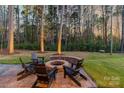Backyard fire pit with stone surround and Adirondack chairs, ideal for outdoor entertaining at 4427 Bright Rd, Charlotte, NC 28214