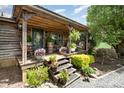 Inviting front porch decorated with plants, flowers, and rocking chairs, showcasing rustic charm at 4478 Fork Rd, Norwood, NC 28128
