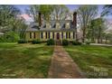 Charming yellow home with blue shutters, brick chimney, and landscaped front yard offers inviting curb appeal at 469 Augusta Dr, Statesville, NC 28625