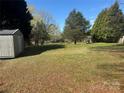 Large, expansive backyard with mature trees, grassy lawn, and shed, offering ample space at 523 29Th Avenue Nw Dr, Hickory, NC 28601