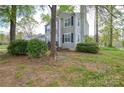 Side view of a charming two-story home with stone accents, black shutters and a nice front lawn at 6020 Running Deer Rd, Charlotte, NC 28214