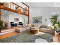 Bright living room with a loft area, hardwood floors, large sofa, area rug and stylish decor at 6147 Lake Providence Ln, Charlotte, NC 28277