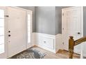 Welcoming entryway with white door, gray walls with white trim, and hard wood flooring at 6301 Baberton Ct, Charlotte, NC 28269