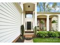 Welcoming front door with sidelights and transom window, plus brick accented porch at 6301 Baberton Ct, Charlotte, NC 28269