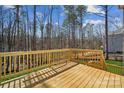View of a wooden deck and railing, backing to a wooded area at 7117 Cobblefield Ln, Denver, NC 28037