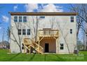 Back exterior view showcasing a spacious deck with stairs to the backyard and multiple windows at 7117 Cobblefield Ln, Denver, NC 28037