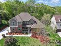 Beautiful home with lush landscaping, mature trees, and a well-maintained lawn at 7798 Sand Trap Ln, Stanley, NC 28164