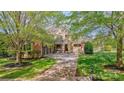 Stately brick home with a stone facade and a lush green lawn at 819 Beauhaven Ln, Waxhaw, NC 28173