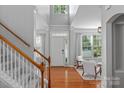 Bright foyer with hardwood floors, staircase, and natural light filtering through the large front windows at 8311 Camberly Rd, Huntersville, NC 28078