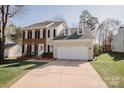 Inviting two-story home with a two-car garage, a lush green lawn and manicured landscaping at 8718 Canter Post Dr, Charlotte, NC 28216