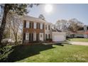 Well maintained two-story home with mature trees, an attached garage and a verdant lawn at 8718 Canter Post Dr, Charlotte, NC 28216