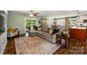 Open-concept living room showcases hardwood floors, a large sectional sofa, and access to the dining and kitchen areas at 9025 Shields Dr, Huntersville, NC 28078