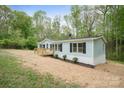 Charming home featuring a light blue exterior, a wooden deck, and black shutters surrounded by lush green trees at 102 Lansdale Ave, Lincolnton, NC 28092