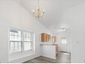 Bright dining area showcasing vaulted ceilings, chandelier lighting, and a view of the kitchen at 10441 Hugue Way, Charlotte, NC 28214