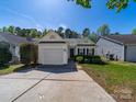 Well-maintained single-story home with lush front yard and a driveway leading to an attached one-car garage at 10441 Hugue Way, Charlotte, NC 28214