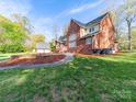 Beautiful backyard features a lush lawn, patio area, and mature trees, perfect for outdoor enjoyment at 106 Berea Baptist Church Rd, Stanfield, NC 28163