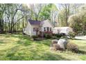 View of the house featuring a detached garage and fenced yard with lush green grass at 11100 Pine Grove Ave, Mint Hill, NC 28227