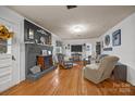 Cozy living room featuring a painted fireplace, hardwood floors, and comfortable seating at 11170 Nc Hwy 73 E Hwy, Mount Pleasant, NC 28124