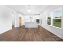 Modern kitchen with white cabinets, a center island, stainless steel appliances, and hardwood floors throughout at 12437 Walker Dr # 89, Stanfield, NC 28163