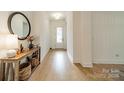 Bright foyer featuring sleek hardwood flooring, fresh paint, and an entry table with decorative mirror and baskets at 1402 Encore Ln, Waxhaw, NC 28173