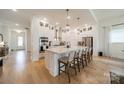 Beautiful kitchen features an island with seating, stainless appliances, custom cabinetry, and hardwood floors at 1402 Encore Ln, Waxhaw, NC 28173