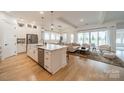 An open-concept kitchen boasts a large island with bar seating, stainless appliances, and hardwood floors at 1402 Encore Ln, Waxhaw, NC 28173