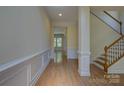 Welcoming foyer with hardwood floors, wainscoting, and a staircase leading to the upper level at 14103 Grand Traverse Dr, Charlotte, NC 28278