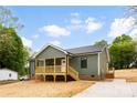 Green sided home with a charming wooden porch, convenient access stairs, and a concrete driveway at 1451 Cherryville Rd, Shelby, NC 28150