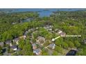 Aerial view of the neighborhood with lush trees and a lake nearby at 19113 Southport Dr, Cornelius, NC 28031