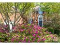 Brick home featuring a charming front entrance framed by lush, vibrant landscaping and flowering bushes at 19113 Southport Dr, Cornelius, NC 28031