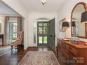 Inviting foyer with hardwood floors, decorative rug, mirror, and views to front yard at 2219 Richardson Dr, Charlotte, NC 28211