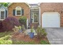 Well-maintained home with brick accents, a cozy entrance, and a two-car garage, surrounded by lush landscaping at 2731 Bishopton Pl, Charlotte, NC 28216