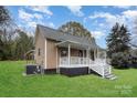 Exterior side view of house featuring a covered porch, well-kept lawn, and vinyl siding at 308 Birch St, Lowell, NC 28098