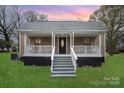 Charming home featuring a covered porch with decorative railings and inviting curb appeal at 308 Birch St, Lowell, NC 28098