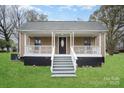 Charming home featuring a decorative front porch, and well-maintained lawn at 308 Birch St, Lowell, NC 28098