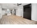 Modern living room featuring an open concept design, sleek floors, and a unique black accent wall at 308 Birch St, Lowell, NC 28098