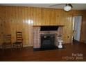 Charming living room featuring a brick fireplace and wood-paneled walls at 311 33Rd Street Se Dr, Hickory, NC 28602