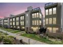 Modern townhome showcasing multi-story facade, manicured lawn, and vibrant greenery, perfect for comfortable urban living at 324 Uptown West Dr, Charlotte, NC 28208
