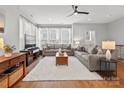 Bright living room with hardwood floors, large windows, ceiling fan, and comfortable seating for relaxation at 324 Uptown West Dr, Charlotte, NC 28208