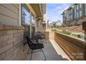 Cozy patio with brick accent, modern seating, and a view of the street, ideal for relaxing outdoors at 324 Uptown West Dr, Charlotte, NC 28208