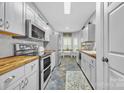 Bright kitchen features white cabinets, butcher block countertops, modern appliances, and tile flooring at 3565 Laboratory Rd, Lincolnton, NC 28092