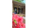 Charming brick home featuring a decorative front door and inviting porch with colorful flower accents at 413 Parallel Dr, Harrisburg, NC 28075