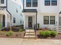 Home's entry with concrete steps, black handrail, and manicured garden featuring shrubs and flowers at 4141 Polluck Way, Charlotte, NC 28209