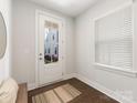 Bright foyer featuring wood flooring, a window with blinds, and a view of the neighborhood at 4141 Polluck Way, Charlotte, NC 28209