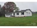 Charming white brick home with black shutters, solar panels, and a well-manicured lawn at 436 Old Nc 90 Hwy, Taylorsville, NC 28681