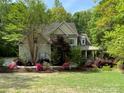 Charming two-story home with manicured lawn and vibrant flowerbeds, surrounded by lush trees at 6108 Mcilwaine Rd, Huntersville, NC 28078